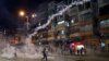 Para demonstran berlarian menghindari gas air mata yang ditembakkan oleh pasukan keamanan dari markas polisi Shum Shui Po, Hong Kong, Rabu malam (14/8). 