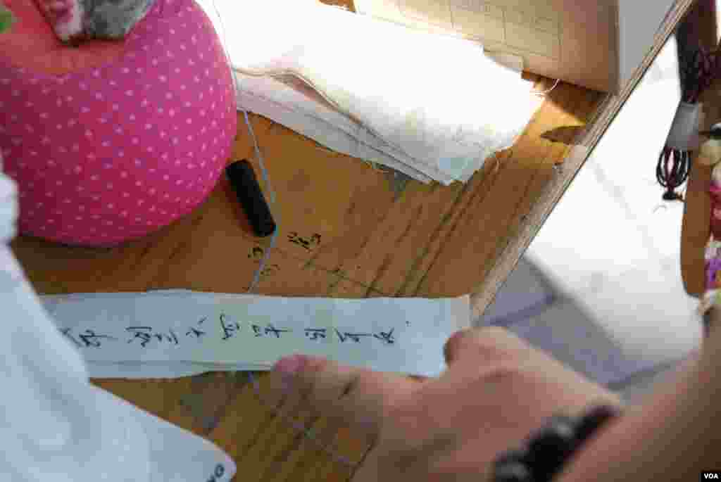 參觀者在小布條上寫上對六四的祝福、感想,放入護身符內