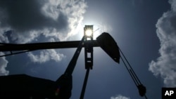 FILE - Oil is pumped from a well near Van, Texas.