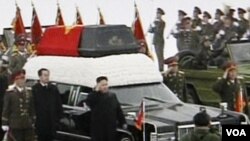 Kim Jong Un berjalan di sebelah peti jenasah mendiang ayahnya dalam prosesi pemakaman Kim Jong Ill di Pyongyang (28/12). Foto diambil dari Sentral Pemberitaan TV Korea Utara.