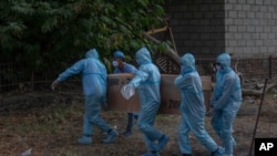 Soldados en India cargan el cuerpo de un colega que falleció por COVID-19 pra su cremación en Srinagar, en la Cachemira India. Julio 18 de 2020.