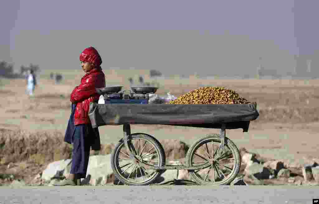 Seorang penjaja Afghanistan menjual kacang di pinggiran Kabul.