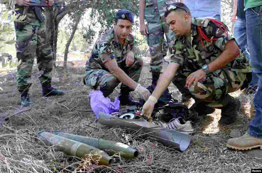 Lebanese army personnel inspect the remains of a shell suspected of having been launched from Lebanon to Israel, near the village of El Mari in southern Lebanon July 11, 2014.