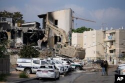 Una excavadora retira los escombros de la comisaría de policía que fue invadida por militantes de Hamás el sábado, en Sderot, Israel, el domingo 8 de octubre de 2023.