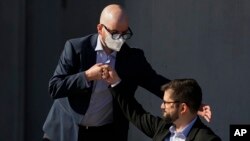 ARCHIVO - El presidente electo de Chile, Gabriel Boric, a la derecha, choca el puño con Giorgio Jackson en un evento para dar a conocer los miembros de su futuro gabinete ministerial en Santiago, Chile, el 21 de enero de 2022. 