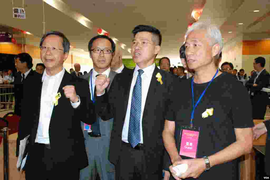 多位泛民主派立法會議員(右起)梁耀忠、范國威、梁繼昌、郭家麒佩帶代表爭取民主的黃絲帶,出席北京官員的政改簡介會示威