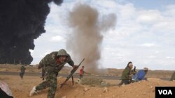 Opositores libios corren a protegerse tras la explosión durante los enfrentamientos en Ras Lanuf este miércoles 9 de marzo de 2011