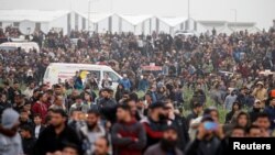 Warga Palestina tampak berkumpul memperingati Hari Tanah Air dan peringatan satu tahun unjuk rasa perbatasan di pagar timur perbatasan Israel-Gaza, Kota Gaza, 30 Maret 2019. 