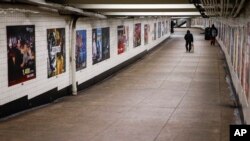 A man walks through an empty underground passage in the Brooklyn borough of New York, Monday, March 16, 2020. (AP Photo/John Minchillo)
