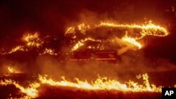 Llamas de contención arden alrededor de un camión de bomberos en Delta en el Bosque Nacional Shasta-Trinity, California.