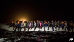 Réfugiés et migrants à bord d'un zodiac surpeuplé, l'embarcation quitte les eaux territoriales libyennes le 5 mars 2017.