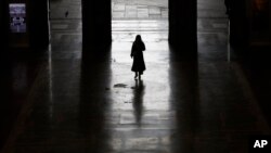 Un passager quitte la gare centrale de Milan, en Italie, le lundi 9 mars 2020. (AP Photo/Antonio Calanni)