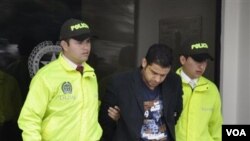 Muhammad Nazaruddin (tengah) dikawal oleh polisi Kolombia di ibukota Bogota, Selasa (9/8). Nazaruddin ditangkap di kota Cartagena hari Minggu pagi (7/8) setelah mendarat dengan penerbangan charter dari Washington, DC.