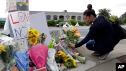 A woman leaves flowers on a growing memorial across the street from the Chabad of Poway synagogue in Poway, California, April 29, 2019. 