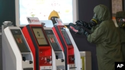 Petugas berseragam dari tim 'hazmat' atau bahan berbahaya memindai mesin-mesin di bandar udara internasional Kuala Lumpur (26/2). (AP/Daniel Chan)