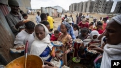 Des Tigréens déplacés font la queue pour recevoir de la nourriture donnée par des résidents locaux dans un centre d'accueil pour personnes déplacées à Mekele, dans la région du Tigré au nord de l'Éthiopie le dimanche 9 mai 2021. (AP Photo/Ben Curtis)
