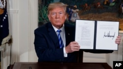 Presiden Amerika Serikat Donald Trump menunjukkan pernyataan yang telah ditandatanganinya terkait keputusan AS menarik diri dari kesepakatan nuklir Iran, di Gedung Putih, Washington, 8 Mei 2018. (Foto: dok).