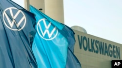 Flags wave in front of a factory building during the production restart of the plant of the German manufacturer Volkswagen AG (VW) in Zwickau, Germany, April 23, 2020.