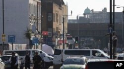 Sebuah tenda forensik dan polisi terlihat di Seven Sisters Road menuju Masjid Finsbury Park pasca insiden sebuah kendaraan menabrak pejalan kaki di London utara, 19 Juni 2017. (AP Photo/Tim Ireland).