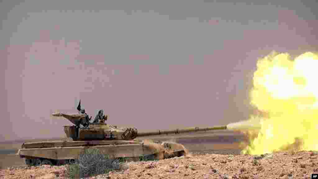 This picture released on May 20, 2015 by the website of Islamic State militants, shows a tank with Islamic State group fighters clashing with Syrian government forces on a road between Homs and Palmyra, Syria.