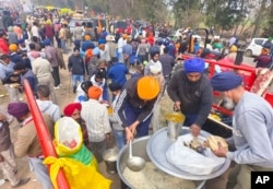 Para petani yang berbaris menuju New Delhi mendistribusikan makanan di dekat perbatasan Punjab-Haryana di Shambhu, India, Selasa, 13 Februari 2024. (Foto: AP)