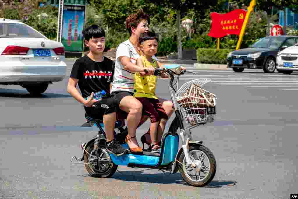 2018年8月28日,在中国河南省滑县,一名妇女带着两个孩子骑车。中国通过放宽计划生育来减缓人口老龄化的举动遇到了意想不到的障碍:许多父母不想生育更多婴儿。根据中国社科院2019年1月的报告, 中国从2011年进入快速老龄化时期,老年人口急速增加,而另一方面人口负增长期即将到来,这造成人口抚养比(劳动力人均承担的抚养人数)逐年增加,人口红利逐渐消失。