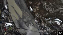 An aerial photo shows overturned cars among destruction in a mud-covered street in Bozkurt town of Kastamonu province, Turkey, Aug. 14, 2021.