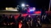 ARCHIVO: Migrantes esperan para ser procesados cerca de Yuma, Arizona, EEUU, el 6 de enero de 2023.