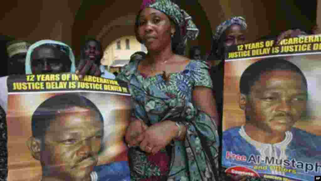 In this 2011 photo, women display a poster of Nigeria's former Chief security officer, Maj. Hamza Al-Mustapha, at the federal high court in Lagos.
