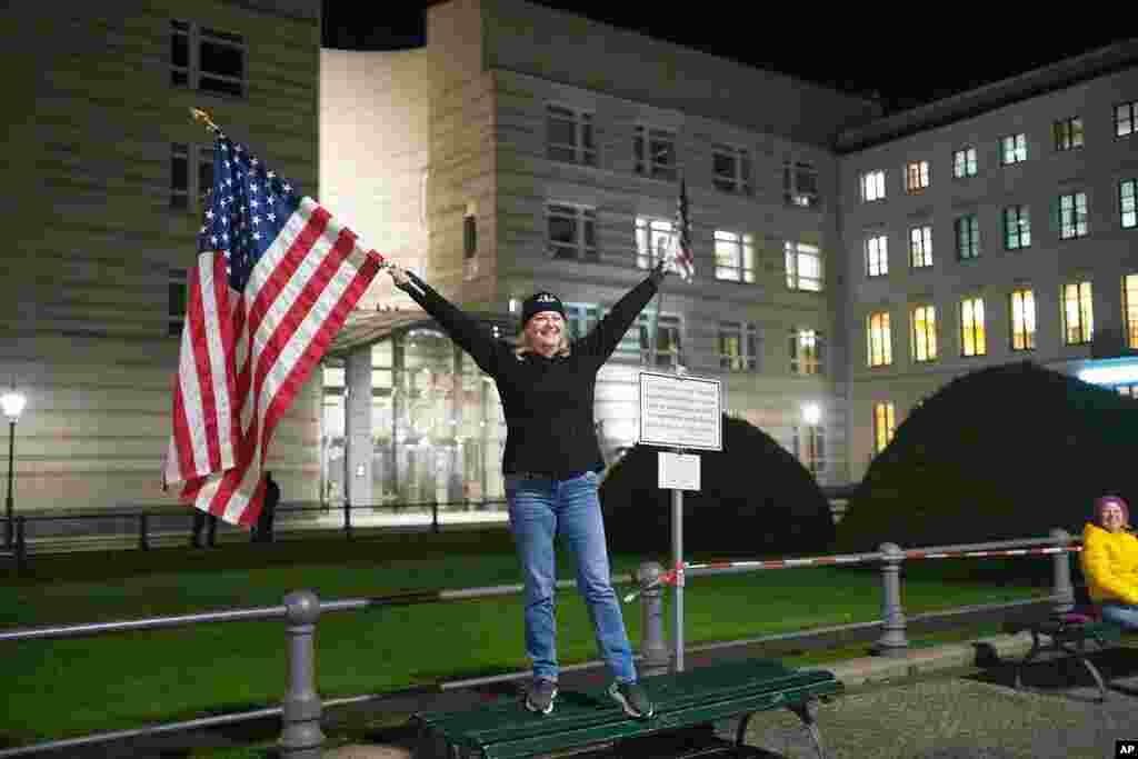 Marianne Hoenow from the U.S. state of Connecticut celebrates the victory of President-elect Joe Biden and Vice President-elect Kamala Harris in front of the U.S. Embassy next to the Brandenburg Gate in Berlin, Germany, Nov. 7, 2020.