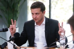 FILE - Ukrainian President Volodymyr Zelenskiy speaks during talks with journalists in Kyiv, Ukraine, Oct. 10, 2019.