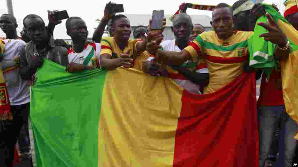 Des supporters maliens acclament leur équipe nationale de football à leur arrivée à l'aéroport international de Malabo à Malabo, Guinée équatoriale vendredi 16 janvier 2015.