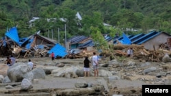 Warga memeriksa rumah-rumah mereka pasca banjir dan tanah longsor di Sentani, Papua, Minggu, 17 Maret 2019. (Foto. Antara/Gusti Tanati via Reuters).