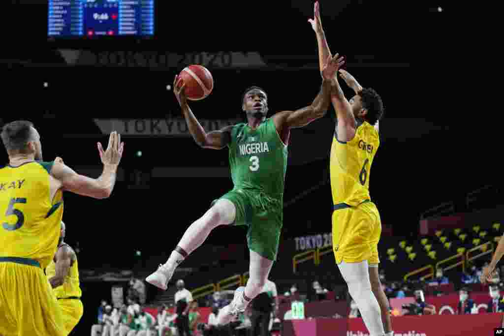 Nigeria's Caleb Agada (3) drives to the basket against Australia's Josh Green (6) during a men's basketball preliminary round game at the 2020 Summer Olympics, Sunday, July 25, 2021, in Saitama, Japan. (AP Photo/Eric Gay)