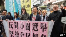 Aktivis Raphael Wong (tiga dari kanan) dari Liga Sosial Demokratik dan peserta unjuk rasa Gerakan Payung Shiu Ka-chun (kanan) bergabung bersama para demonstran lainnya menuju lokasi pemilihan Eksekutif Hong Kong, 26 Maret 2017 (Foto: AFP).