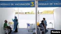 Trabajadores de la salud administran vacunas contra COVID-19 en un centro de vacunación en Santiago, Chile, el 17 de marzo de 2021.