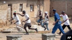Milice de jeunes pro-gouvernementaux Imbonerakure poursuivant des manifestants de l'opposition, dans le district de Kinama à Bujumbura, au Burundi, le 25 mai 2015.