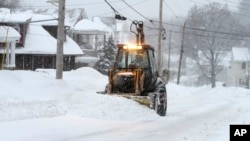 Una pala mecánica remueve la nieve en Marlborough, Massachusetts donde se espera entre 30 y 60 centímetros más de nieve.