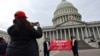 Поддржувачи на Трамп се фотографираат пред зградата на американскиот конгрес во Вашингтон на 18 јануари, 2025