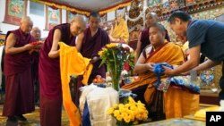 Monks bow and present “khata” to teenage Buddhist lama, Jalue Dorje, at his 18th birthday and enthronement ceremony in Isanti, Minnesota, Nov. 9, 2024. 