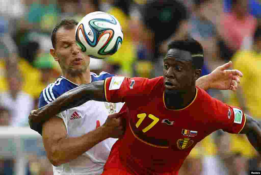 Russia's Sergey Ignashevich fights for the ball with Belgium's Divock Origi during their match at the Maracana stadium in Rio de Janeiro, June 22, 2014.