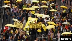 Para demonstran membawa jendela kuning, simbol gerakan Occupy Central, berbaris di sebuah jalan di Hong Kong, 1 Februari 2015.