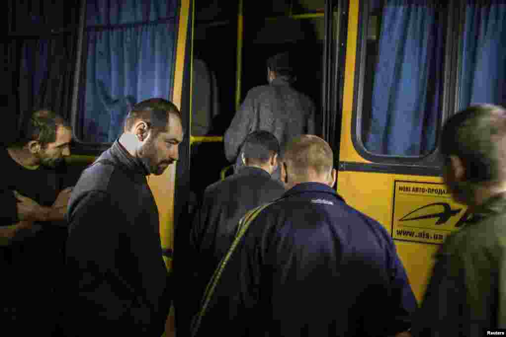 Members of the pro-Russian rebels, who were held as prisoners-of-war, enter a bus after being exchanged, north of Donetsk, eastern Ukraine, Sept. 21, 2014.