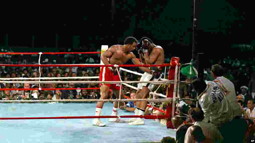 Le champion du monde George Foreman conduit son challenger Muhammad Ali dans les cordes avec un jab de gauche au corps pendant le combat de championnat WBA / WBC à Kinshasa, au Zaïre, le 30 Octobre, 1974. Ali a repris la couronne des poids lourds en assommant Foreman au cours du huitième round de leur combat surnommé «Rumble in the Jungle». (AP Photo)