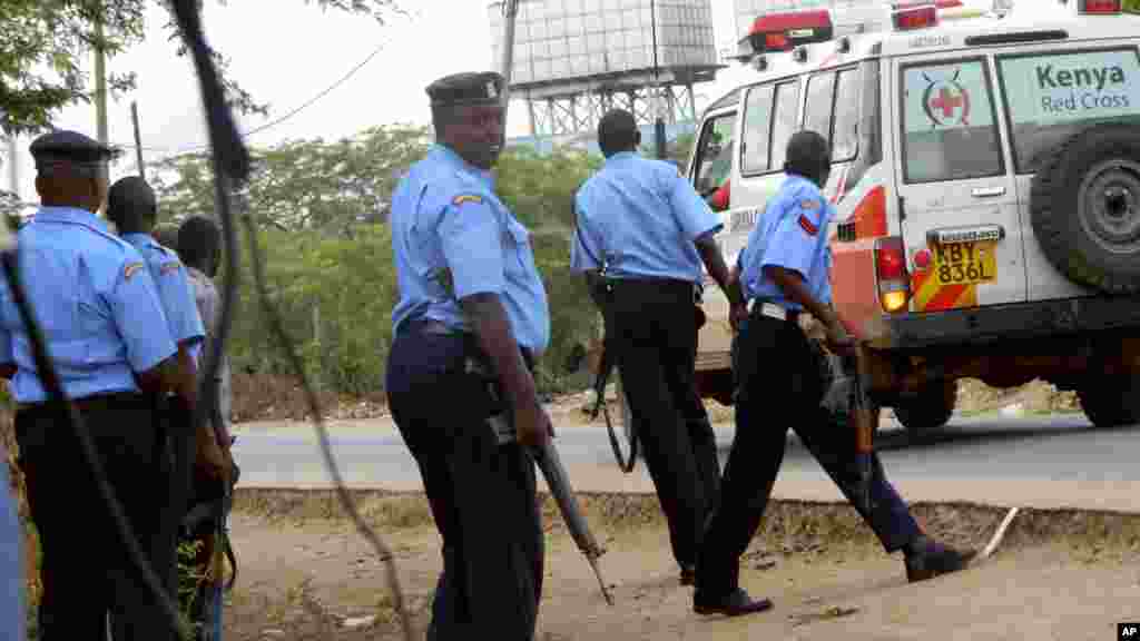 Des policiers kenyans prennent position à l'extérieur de l'université de Garissa alors qu'une ambulance transporte les blessés aller à l'hôpital, après une attaque des hommes armés à Garissa, au Kenya, jeudi 2 avril 2015.