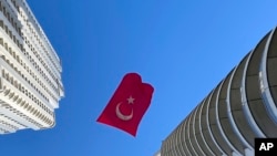 Un drapeau turc suspendu entre deux gratte-ciel flotte au vent, à Istanbul, jeudi 23 avril 2020.