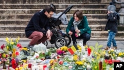 Une famille allume des bougies Place de la Bourse, Bruxelles, 27 mars 2016