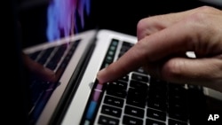 ARSIP – Foto arsip yang diambil tanggal 27 Oktober 2016 ini menunjukkan seorang pengunjung yang mengamati fitur Touch Bar pada komputer MacBook di sebuah ruangan demo setelah pengumuman produk-produk baru di kantor pusat Apple di Cupertino, California (foto: AP Photo/Marcio Jose 