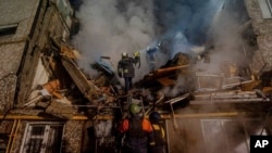 ARCHIVO - En esta imagen distribuida por el Servicio de Emergencias de Ucrania el 13 de marzo de 2024, operarios del departamento trabajan en un edificio de apartamentos destruido por un ataque ruso, en Sumy, Ucrania.