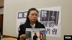 李明哲的妻子李淨瑜向媒體展示李明哲以往活動的照片(美國之音楊明拍攝) 